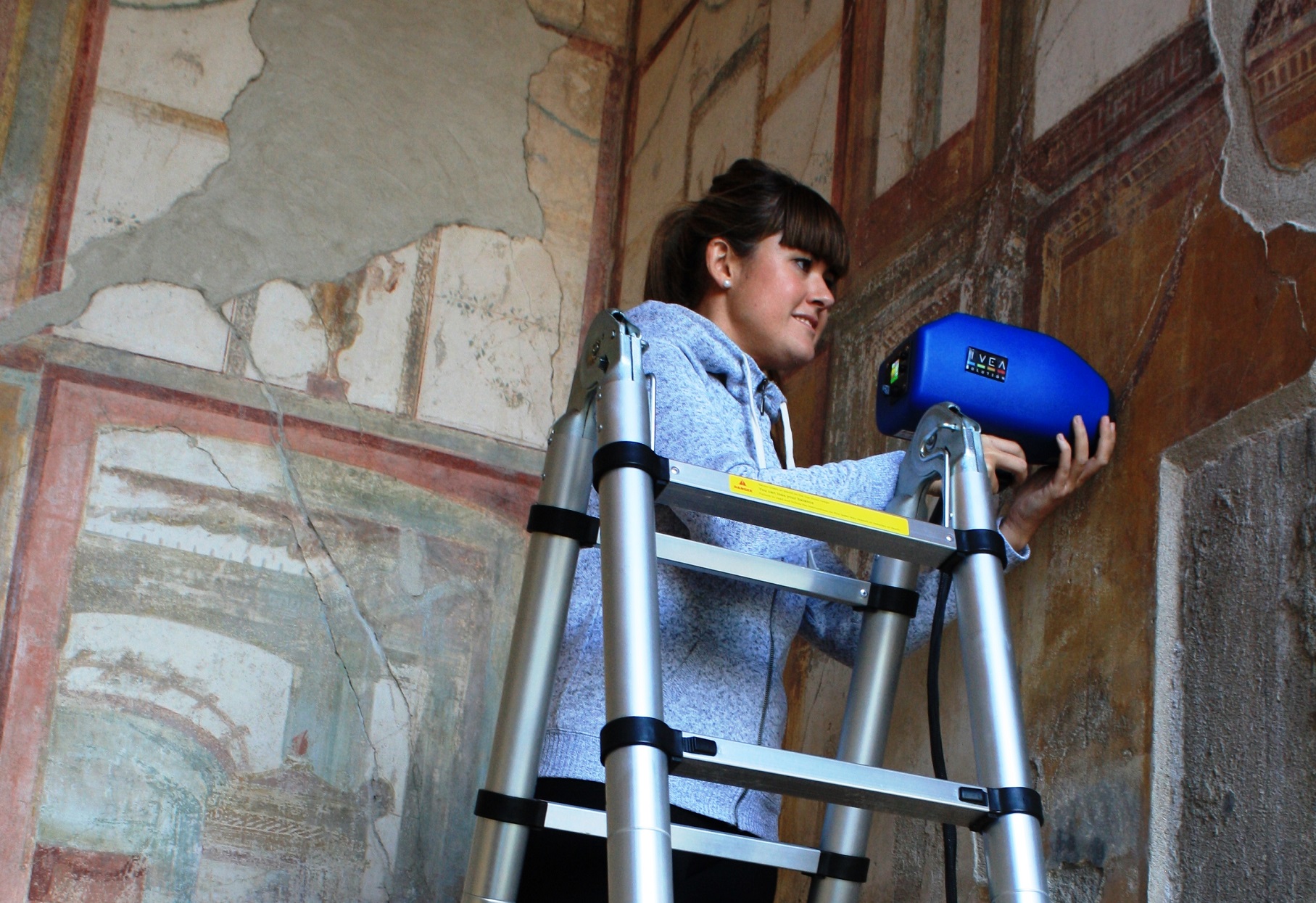 La doctora del grupo IBeA Maite Maguregui, realizando mediciones con herramientas portátiles en las pinturas murales de Pompeya